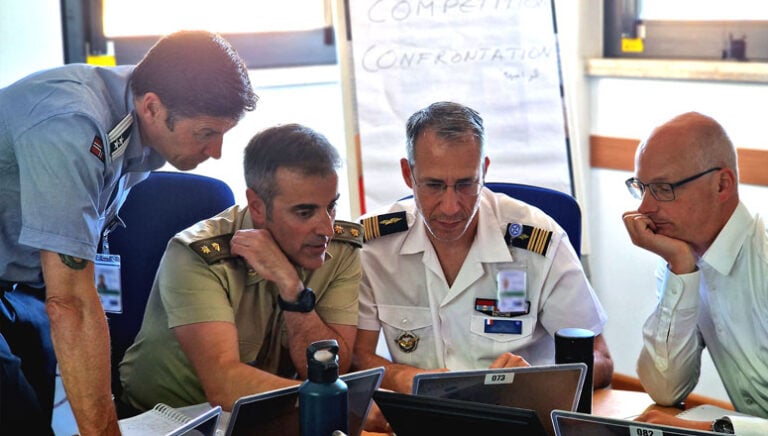Course Members engaging in discussions within their respective roles in the committee rooms during the NMDX exercise.